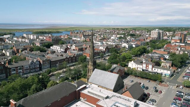 Southport, Lancashire, UK, June 19, 2023; Mid-level aerial orbital clip video footage of St George's URC Church with tall spire on Lord Street in Southport, England