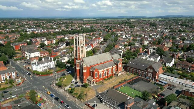 Southport, Lancashire, UK, June 19, 2023; Mid-level aerial orbital clip video footage of Trinity Church with tall tower on Houghton Street in Southport, England