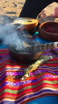 Mystical andean journey: peruvian blanket, charango, herbs, natural ingredients, crystals and burning holy wood incense in the desert sand