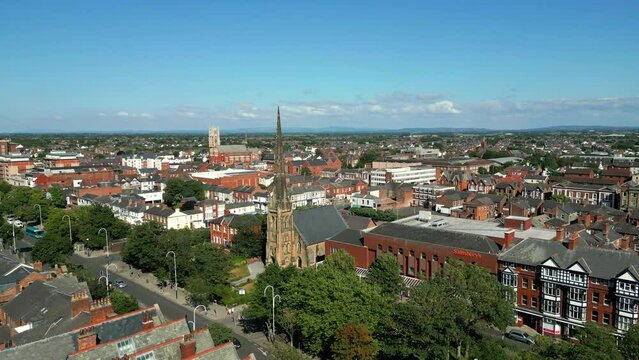 Southport, Lancashire, UK, June 24, 2023; Mid-level aerial fly by clip video footage of St George's URC Church with tall spire on Lord Street in Southport, England