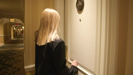 View of formally dressed female girl in Luxury modern room corridor. Woman opens the door to hotel room, using NFC key card, check in to the apartment. Arriving on business trip. High quality 4k