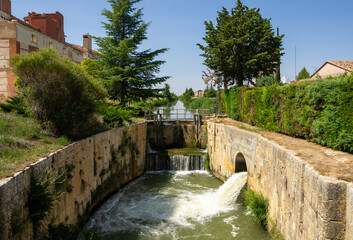 Fototapeta na wymiar Imagen horizontal de la esclusa 33 del canal de Castilla en la provincia de Palencia. Cascada de agua.