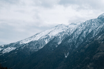 Fototapeta na wymiar mountain peaks in gray clouds. Mountain landscape.Mountains and sky in gloomy blue tones. mountain landscape.Tyrol,Austria. Beautiful mountain landscape with cloudy sky.