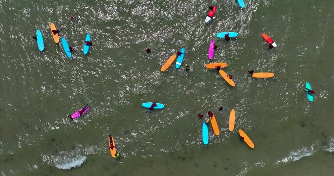 Top view of the beach with surfers practising their wave 4k