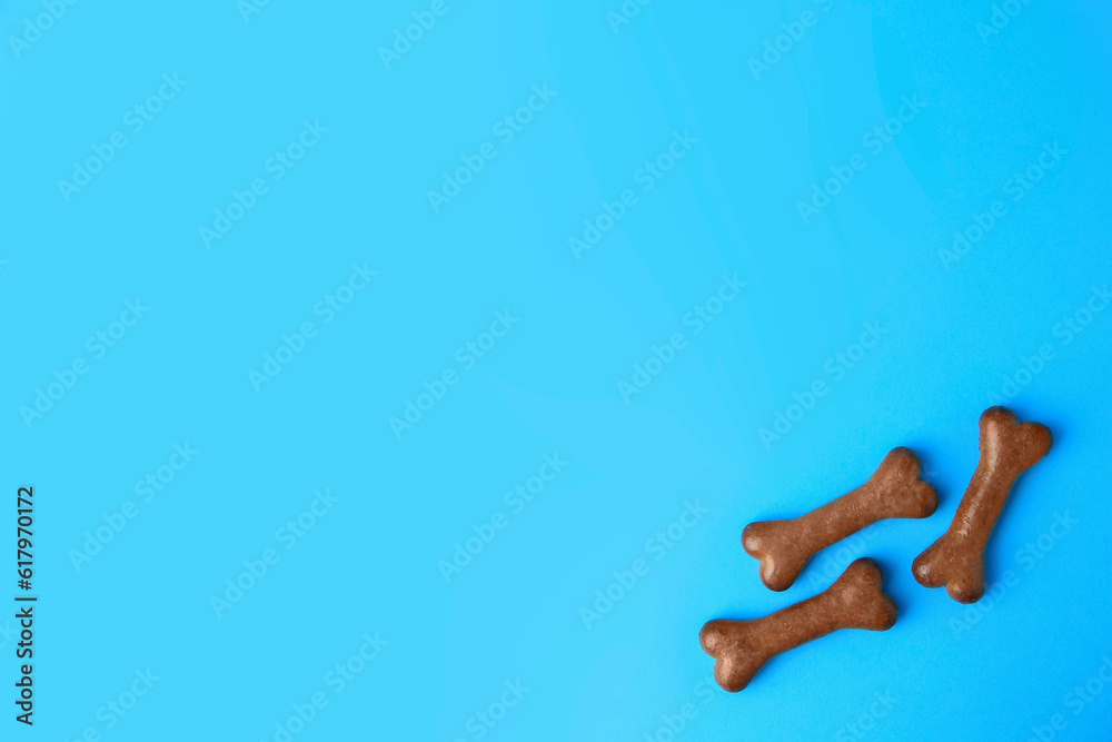 Wall mural Bone shaped dog biscuits on light blue background, flat lay. Space for text - Wall murals
