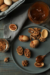 Freshly baked homemade walnut shaped cookies with nuts and boiled condensed milk on wooden table, flat lay