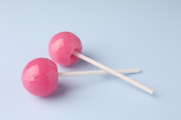 Tasty lollipops on light blue background, closeup