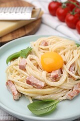 Delicious pasta Carbonara with egg yolk on table, closeup