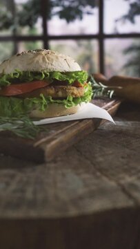 delicious healthy vegetarian vegan homemade burger on a wooden plate decorated with rosemary and lavender vertical