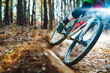 A mountain biker zooms around a curving singletrack trail in a North Carolina forest in autumn, extreme closeup