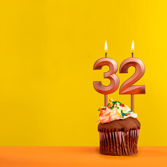 Candle with flame number 32 - Birthday card on yellow background