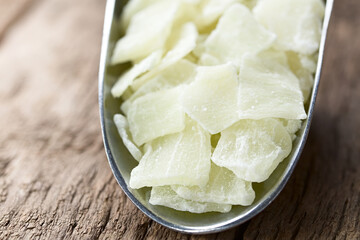 Candied or glace aloe vera gel slices in metal scoop on wood (Selective Focus, Focus one third into...