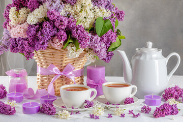 summer breakfast concept. tea in cups and lilacs on the table