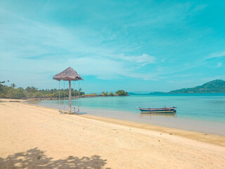 beautiful beach scenery, there are ships and swings with a bright sky background
