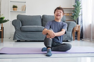 Senior woman relaxing and laughing when finish  stretching exercise yoga in living room at home.