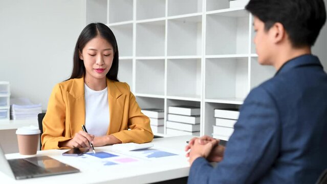 Two business workers talking on the smartphone and using laptop at the office..