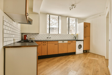 a kitchen with wood flooring and white tile on the walls, in an empty room next to a washing machine
