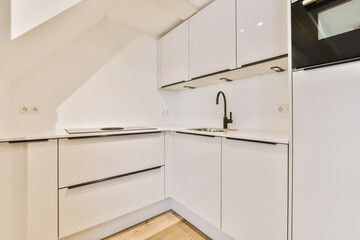 a kitchen with white cupboards and black trim on the cabinets in an attic - style home, which is ideal for small spaces