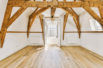 an empty room with wood floors and wooden beams on the ceiling, looking towards the entrance to the living room