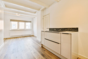 an empty kitchen with white cabinets and marble counter tops on the island in this room has wood floors, hardwood flooring
