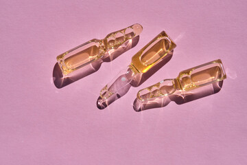 Ampoules on a pink background on the sun.