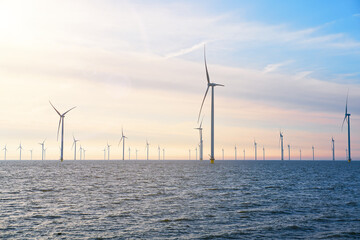 Offshore Windmill farm. windmills isolated at sea on a beautiful bright day Netherlands. green energy Flevoland global warming renewable enrgy with windmills - obrazy, fototapety, plakaty