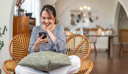 Portrait of smiling happy asian woman relax using digital smartphone.Young asian girl working or study,chatting social network and playing game online or social media,shopping online at home