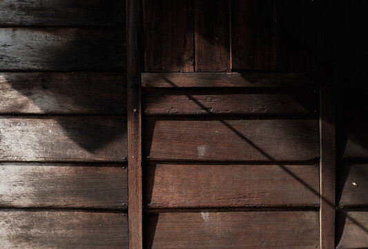 traditional malay wooden house wall with morning sunlight and shade.