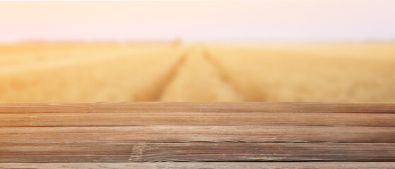 Empty wooden table in golden wheat field