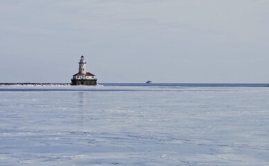 lighthouse on the shore of the river over the ice lake