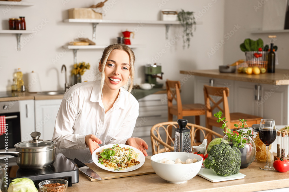 Canvas Prints young woman with tasty pasta in kitchen