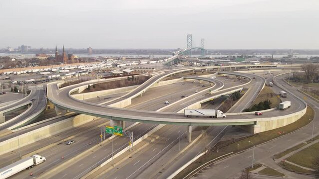 Cars and trucks driving on I75 road leading to Ambassador bridge, aerial drone view