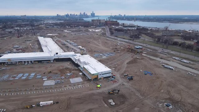 Commercial building construction site with skyline of Detroit in horizon, aerial view