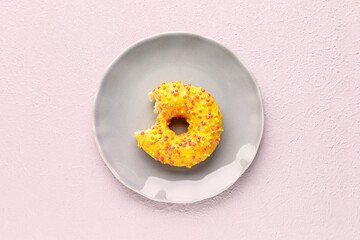 Plate with sweet donut on light background