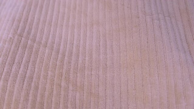 close-up of the relief texture of beige corduroy trousers, ribbed cotton trousers, pants, checks their quality, new purchase, fashionable clothes
