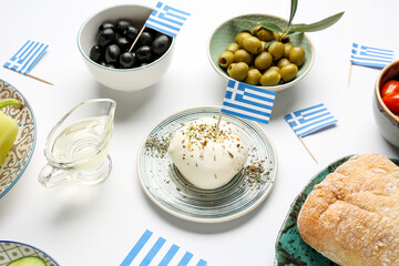 Plates with mozzarella cheese, olives, ciabatta and flags of Greece on white background