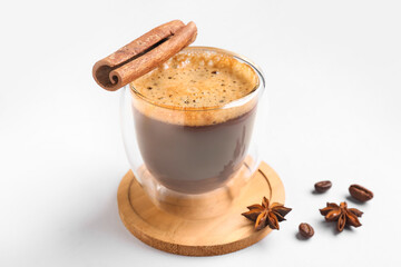 Glass cup of hot espresso with cinnamon on white background