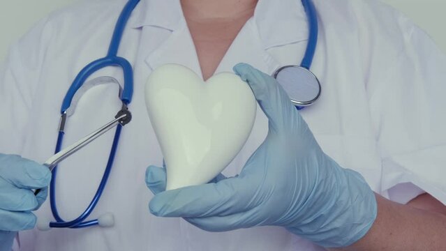 female scientist, doctor holding heart model, microprocessor, microchip, biochip tweezers for immunocytochemical studies heart, treatment cardiovascular disease, experimental nanotechnology medicine