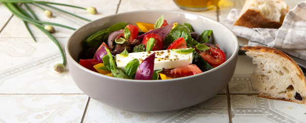 bowl with traditional greek horiatiki salad on light table
