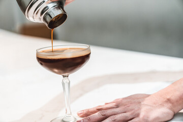 Bartender making alcoholic coffee cocktail. Serving summer cocktail in bar.