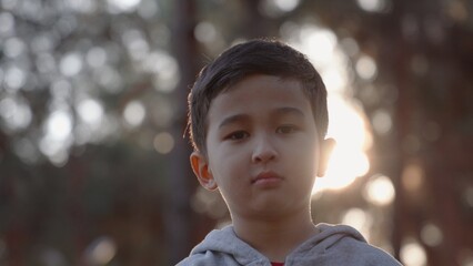 Portrait little boy looking at camera. Young laughs happily.