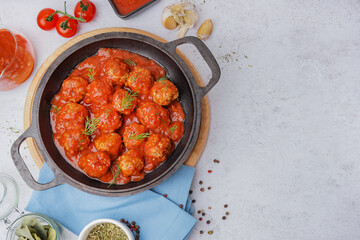 Frying pan of tasty meat balls with tomato sauce and dill on white background