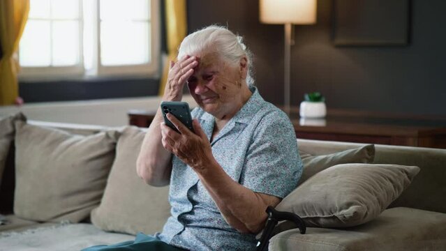 Frustrated sad senior aged 80 years  old woman reads bad news or seeing photos feels shocked using phone