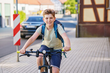 Handsome preteen boy going to school on bike. Teenager ride bicycle. Safe way to high school. Happy...