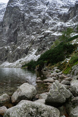 Czarny Staw pod Rysamy or Black Pond lake near the Morskie Oko Snowy Mountain Hut in Polish Tatry mountains, drone view, Zakopane, Poland. Aerial view shot of beautiful green hills and mountains in