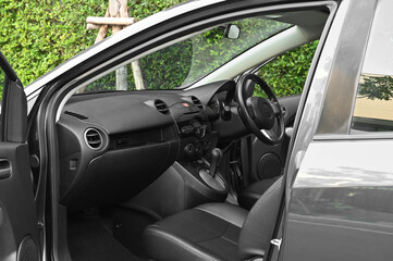 Inside the car, driver's seat, steering wheel, and dashboard.