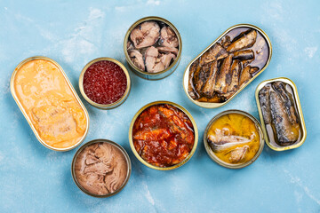 Variety of opened tins with different types of canned fish and seafood. Natural source of omega 3...