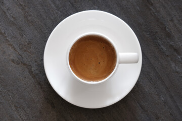 Obraz na płótnie Canvas White cup of coffee on dark background flat lay
