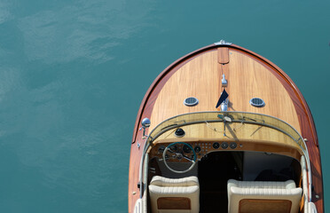 Expensive wooden lacquered part of the boat. Fore deck. Part of a wooden boat on a blue background...