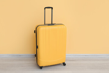 Suitcase near yellow wall. Travel concept